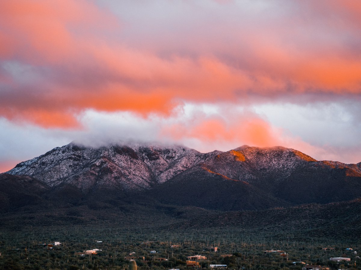 a few days ago, we had DAYTIME SNOW in tucson, arizona. here's a photo i took of mountains in saguaro national park at sunset.