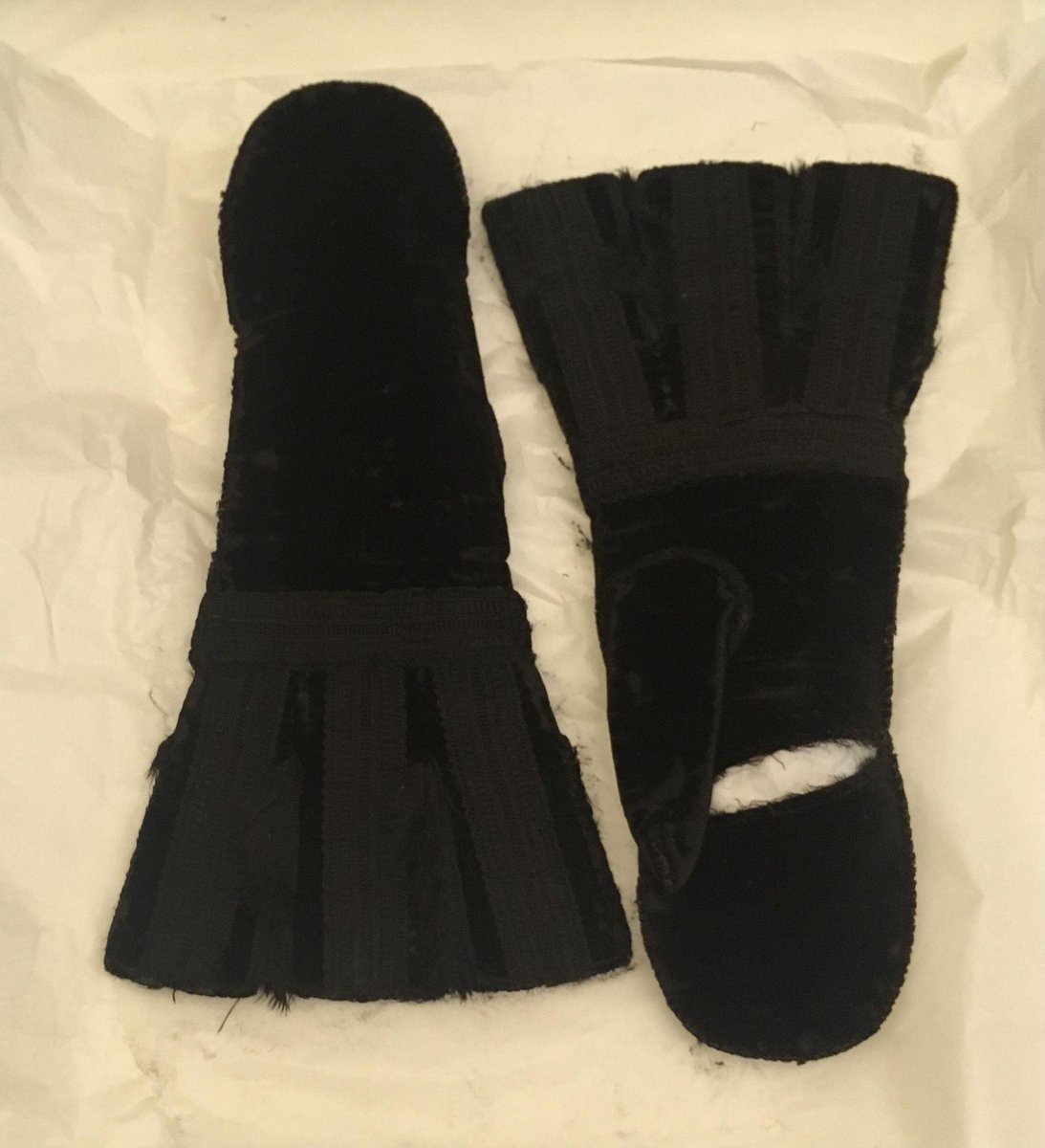 A pair of black silk velvet mittens lined with silk plush, Made in Britain, c. 1600 (V&A Museum, London) The palms of each mitten have a horizontal opening to free up the fingers when desired.