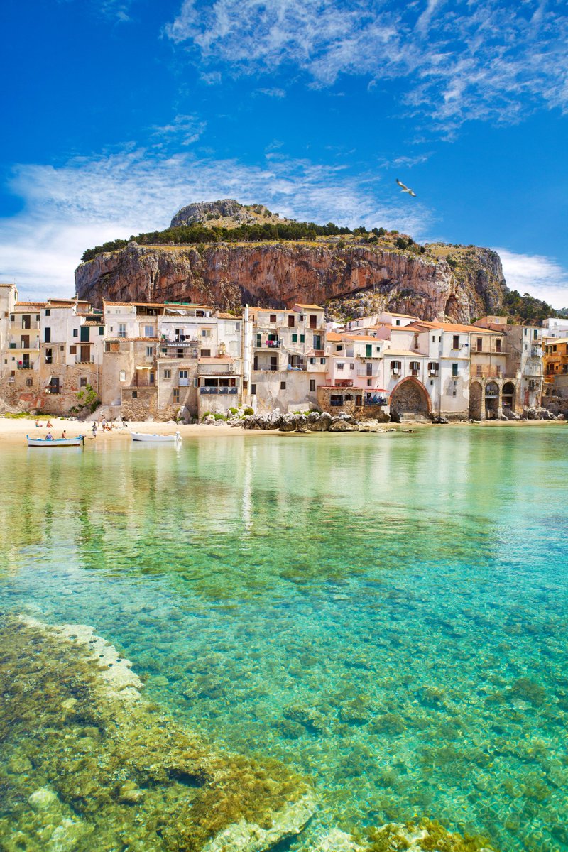 CNTravelerSpain's tweet photo. Cefalú es una parada indispensable en Sicilia. Las playas son, junto a su catedral, la postal más representativa de esta ciudad italiana: el mar cristalino llega a los pies de las casas antiguas, cuyas terrazas cuelgan dramáticamente sobre él 💙🌊  (📸 Alamy) https://t.co/7v7zMPQCBX