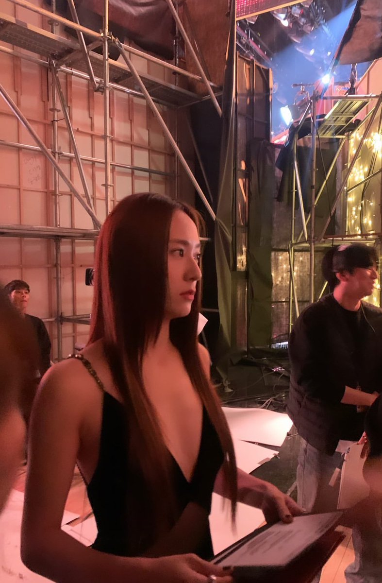 In the midst of the bustling photoshoot, I still radiate beauty, adorned in an elegant black gown.