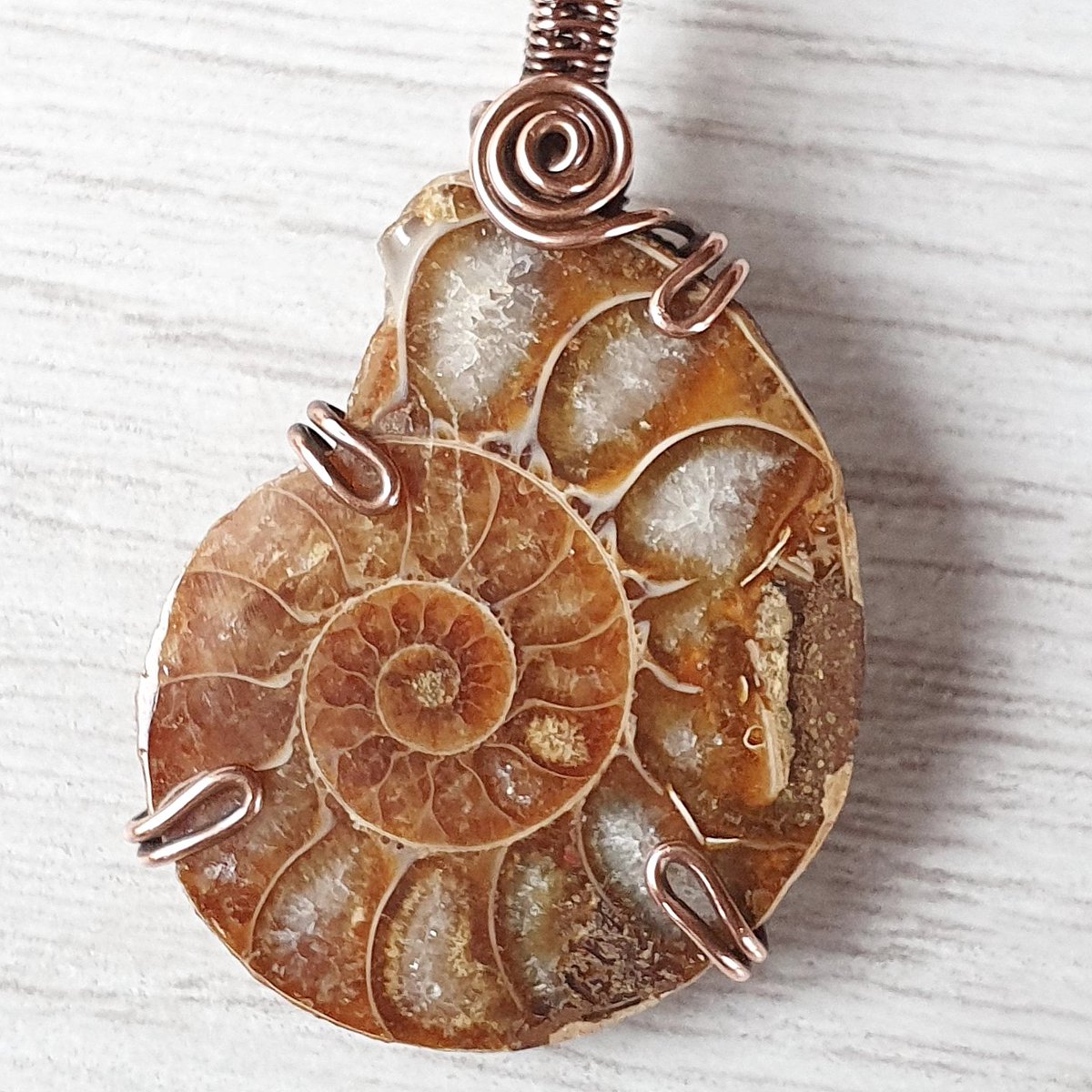 OrphicCrystal's tweet photo. This #handmade #pendant features ancient #ammonite wrapped in raw copper. I love how it holds so much history &amp; like to think that it must have witnessed so much over the centuries. Imagine all the #Wisdom it must contain! #smallbiz #crystaljewelry #handmadejewelry #giftideas https://t.co/0ruYwdGOKO