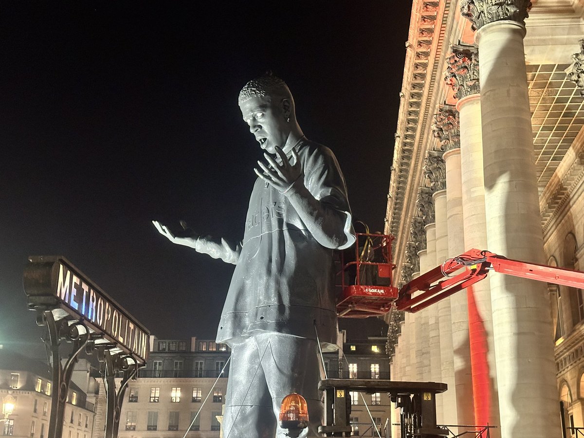 andrepitie's tweet photo. Who is this ? Who made this massive statue ? Paris Bourse (former stock exchange building) tonight, France. Nike Air shoes, Raders logo on the T-shirt. https://t.co/xuMR6NrwJF