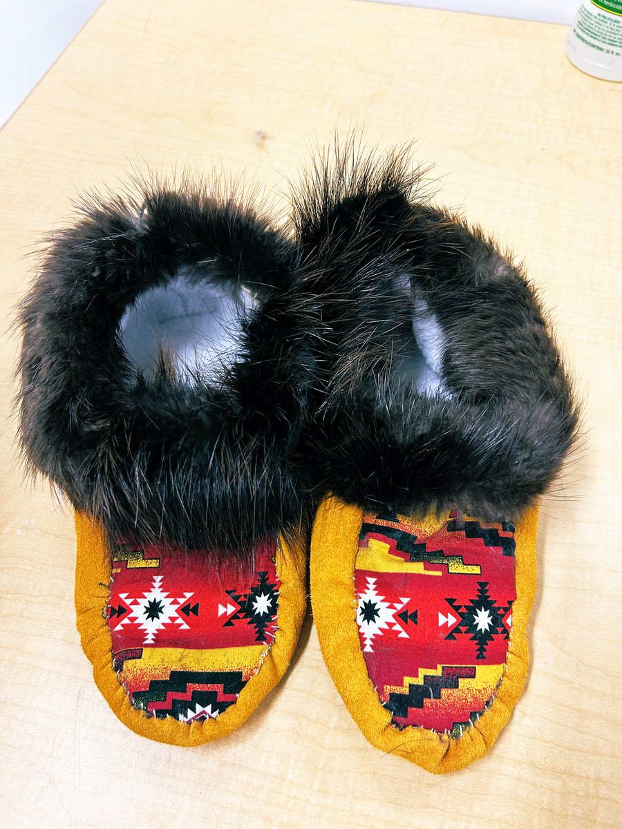 LisaMactbay's tweet photo. A lot of hard work getting these done ✔️. They did such awesome work — first time sewing 🧵  🪡 and all smiles when they finally see the finished products @HammarskjoldP #KZLodgeprogram2024 #moccasins https://t.co/bP7oOGxf3S