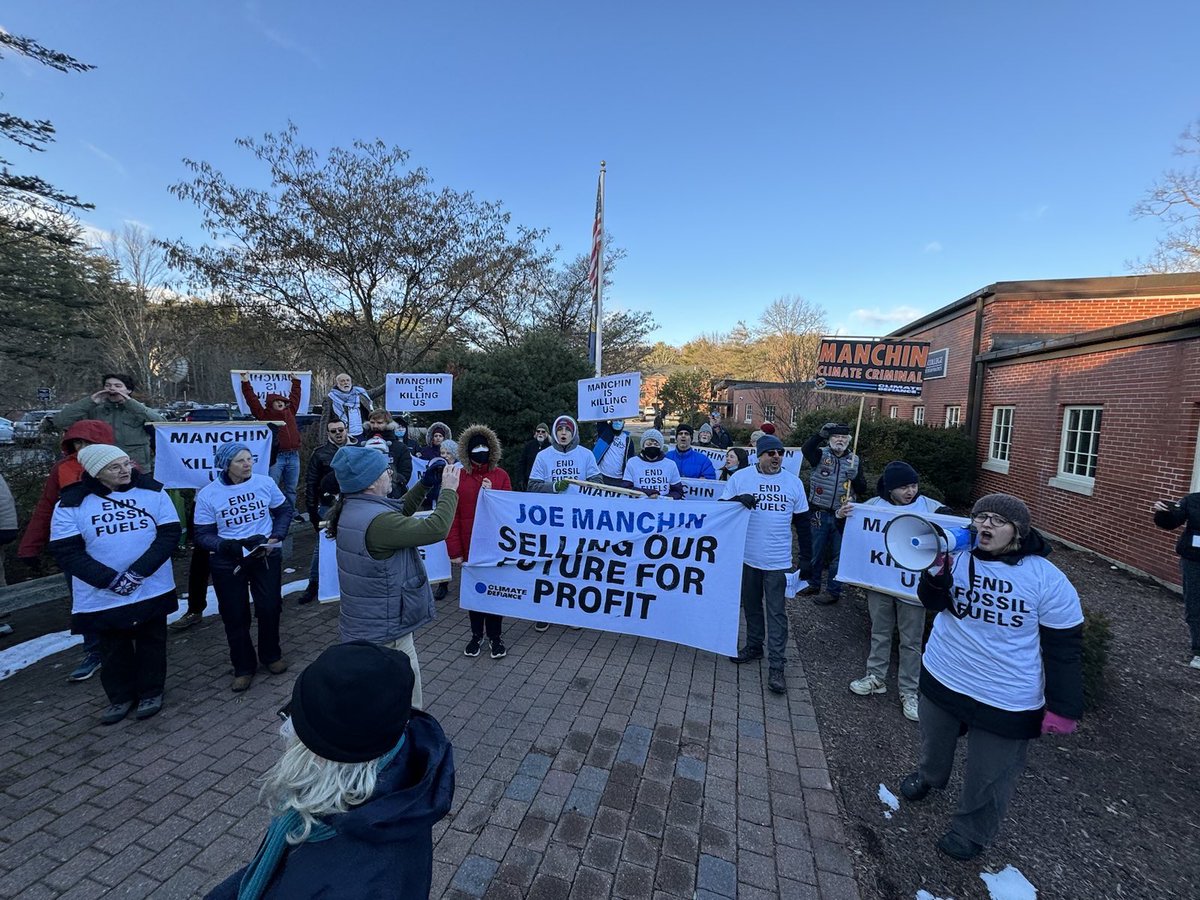 ClimateDefiance's tweet photo. BREAKING: we are *swarming* Joe Manchin’s presidential forum in New Hampshire. This man is a murderer. The blood of thousands is encrusted on his hands. As we write he cowers behind lines of armed cops, afraid and humiliated. https://t.co/v7VuuWjZW2