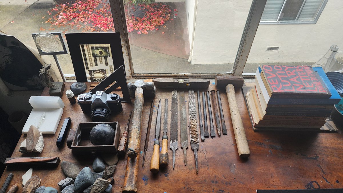 my father's stone carving tools, books, clay tools, sandcasting tools, camera. one of his small bronze sculptures. i use all of these tools still in my own practices but reposition them in their dual function as ofrenda, the way they've been since he passed last march.