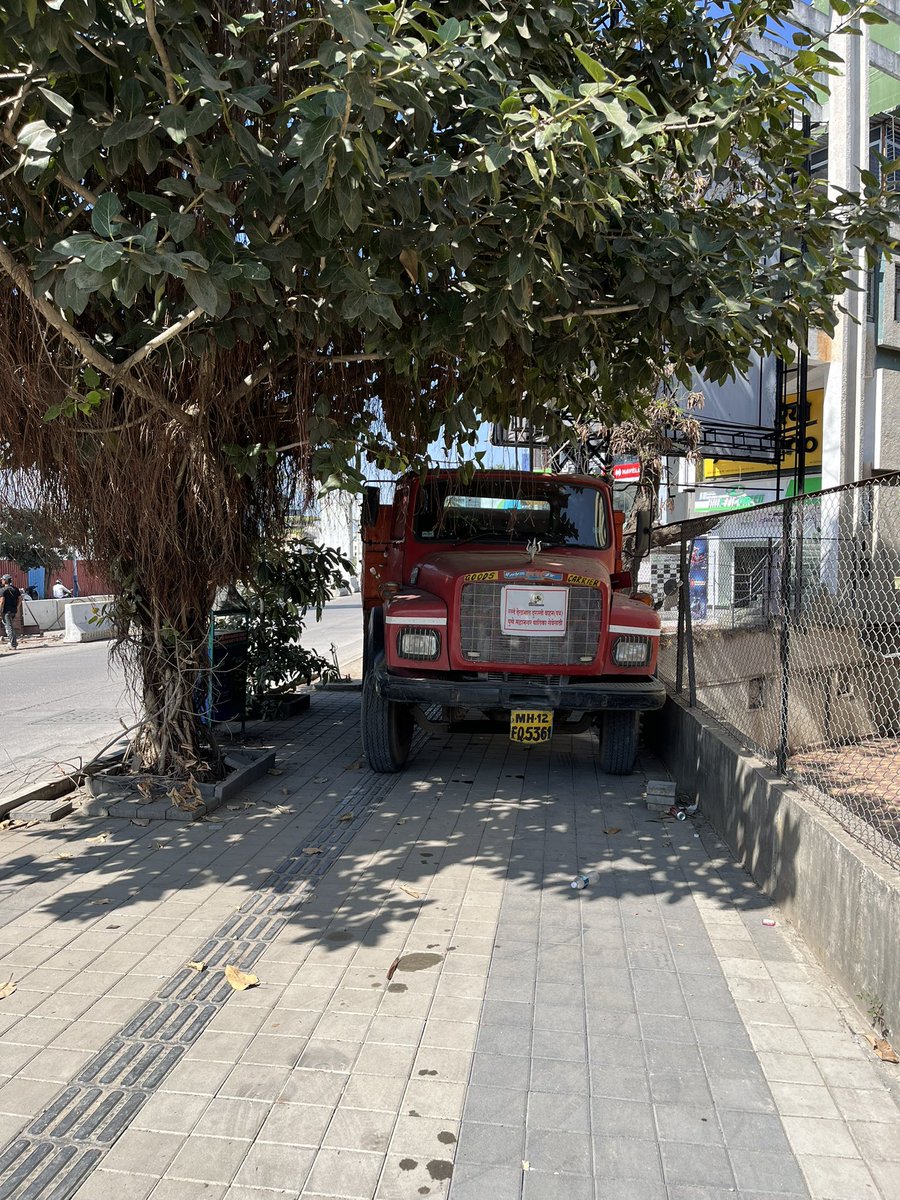 rakesh1908's tweet photo. PMC duty truck on footpath resting under the tree and people walking on the road under the sun. This is near Sreenivas Classic Baner Road. #PMC https://t.co/mkSmKLJn6b