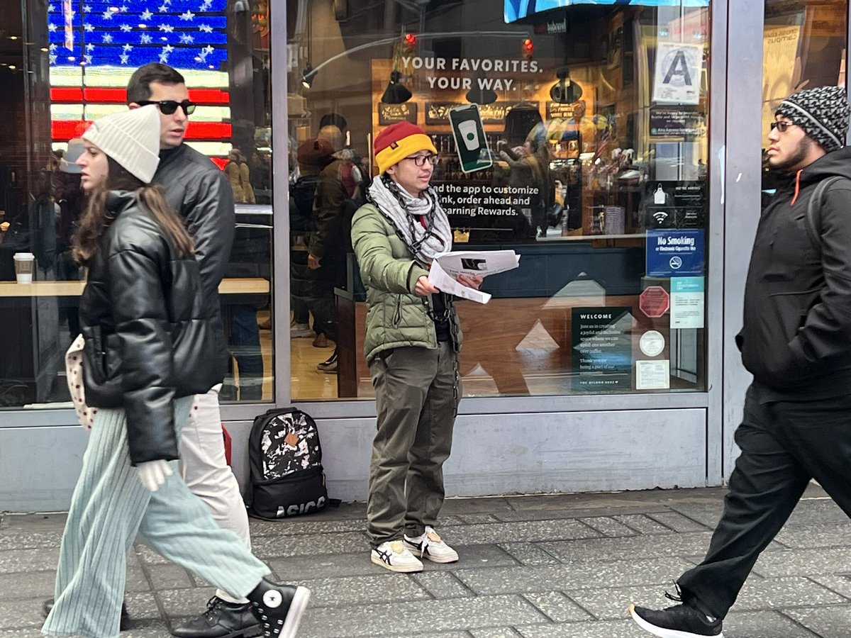 ZhouFengSuo's tweet image. 王涵在曼哈顿时代广场绝食纪念铁链女被发现两周年。在熙攘人群中一个个的发送传单，人流中孤单而平常，但是
他今天已经送出一百多张。他的精神感动了旁边的店主，他破例让王涵把传单贴到售货亭。他的脖子上也缠绕了铁链。寒冷的冬天，还会下雨，而他要坚持一周。