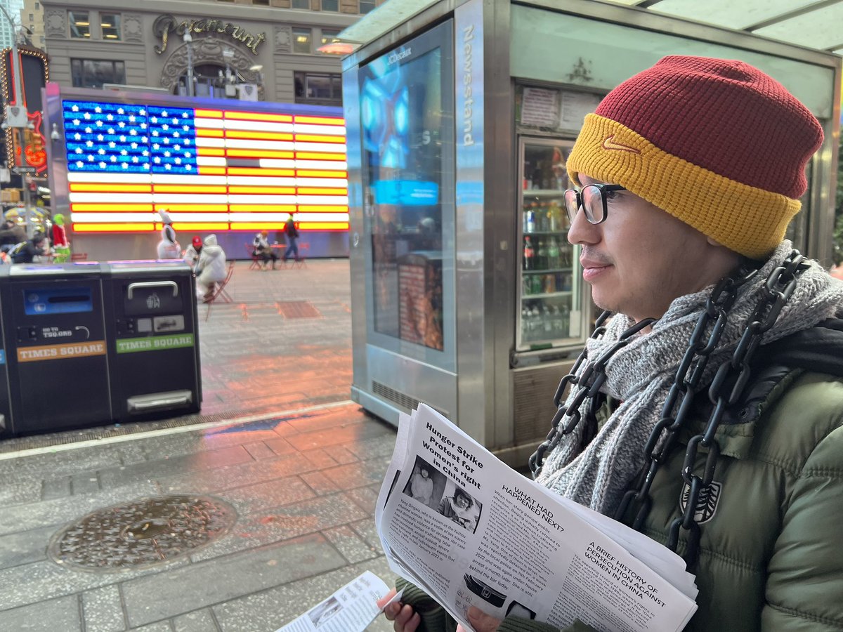 ZhouFengSuo's tweet image. 王涵在曼哈顿时代广场绝食纪念铁链女被发现两周年。在熙攘人群中一个个的发送传单，人流中孤单而平常，但是
他今天已经送出一百多张。他的精神感动了旁边的店主，他破例让王涵把传单贴到售货亭。他的脖子上也缠绕了铁链。寒冷的冬天，还会下雨，而他要坚持一周。