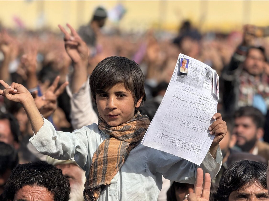 On one hand holding report of a missing person (most probably his father’s) ,on the other waiving sign of victory and eyes full of hope🌹.