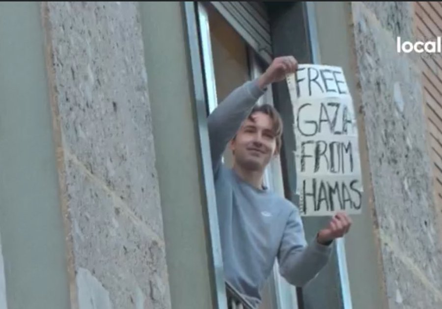 Milano, alla finestra con il cartello «Free Gaza from Hamas»: insulti dal corteo pro-Palestina e la visita della polizia. #GiornataDellaMemoria