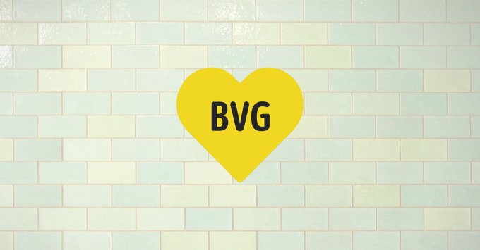 BVG Herz-Logo in gelb auf einer U-Bahn-Fliese in hellem grün.