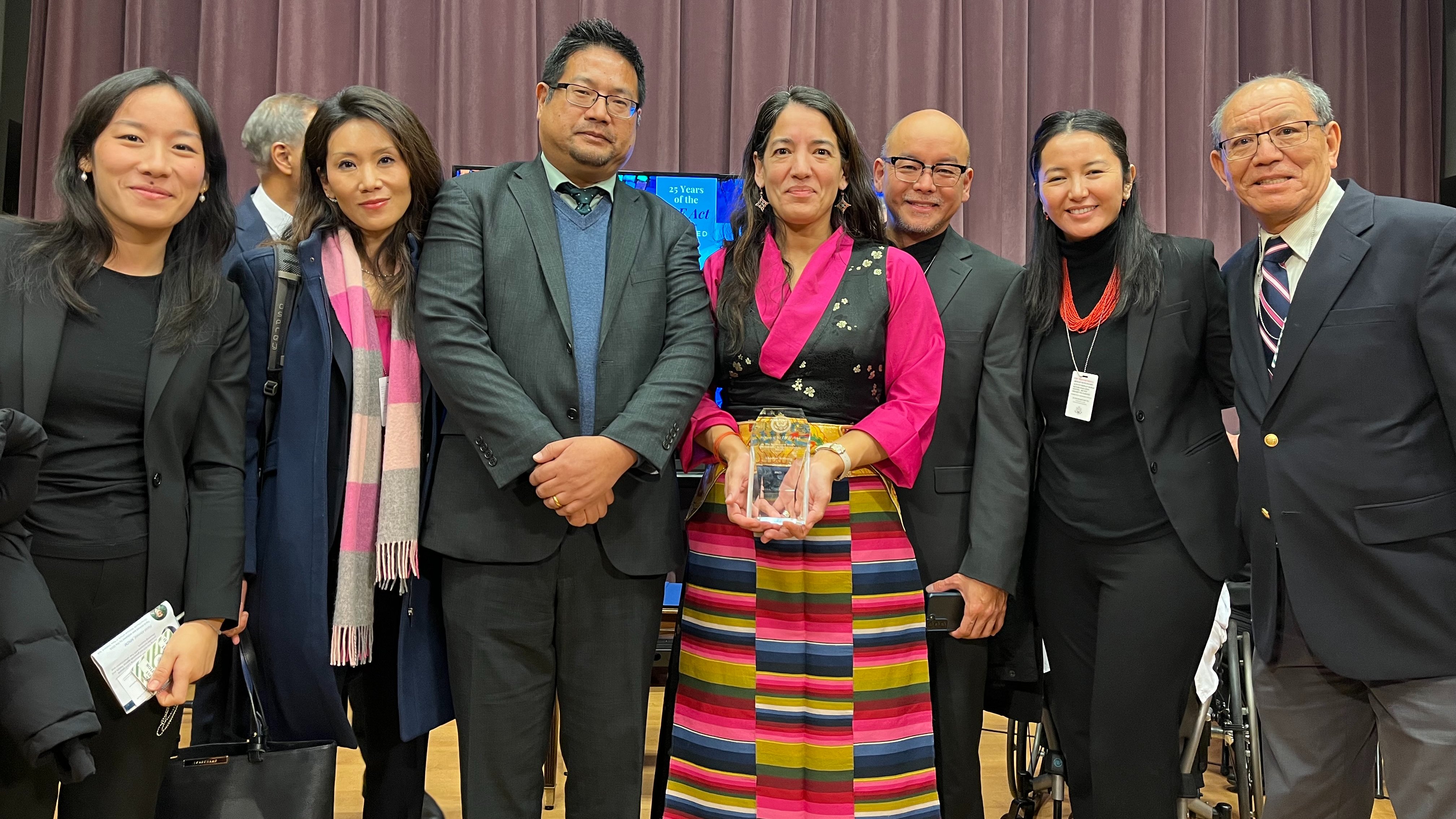 Lhadon Tethong posing with the trophy accompanied by Representative of Office of Tibet