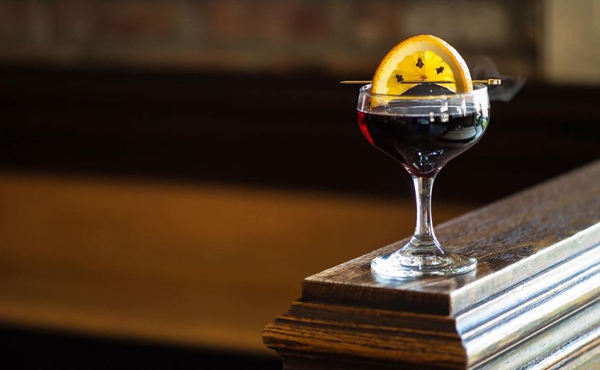 PieceofLea's tweet photo. A LOOK AT A PRE-CIVIL WAR DRINK -- A “SMOKING BISHOP” FEATURED IN CHARLES DICKENS' "A CHRISTMAS CAROL"
Charles Dickens’s drinking knowledge was as epic as his tales, many of which include passing descriptions of the Victorian era’s drinking rituals.
The Smoking Bishop happens to fall into a family of punch-style drinks named for the clerical hierarchy. The Pope involved mixing with Burgundy while Archbishop employed claret and the Cardinal, Champagne.
In a final scene in "A Christmas Carol," Scrooge turns to Bob Cratchit, his belittled employee, with new eyes and invites him to be merry over a bowl of Smoking Bishop—the word “bishop” was 19th-century code for port—which referred to a roasted clove and orange-infused port punch, warmed and mulled with baking spices and further fortified with red wine.
HERE'S HOW TO MAKE YOUR OWN "SMOKING BISHOP."
INGREDIENTS
Servings: 10-12
750 ml ruby port
750 ml red wine
1 cup water
1/2 cup brown sugar
1/4 teaspoon ginger, freshly grated
1/4 teaspoon allspice, ground
1/4 teaspoon nutmeg, freshly grated
4 oranges
20 cloves, whole
Garnish: clove-studded orange slice
DIRECTIONS
Preheat oven to 350 degrees.
Wash and dry oranges. Pierce and stud each orange with five cloves.
Place oranges in a baking dish and roast until lightly browned all over, 60-90 minutes.
Add port, wine, water, sugar, and spices to a saucepan, and simmer over low heat.
Slice oranges in half and squeeze juice into the wine and port mixture.
Serve in a punch bowl, and ladle into individual glasses.
If you're interested in mixed drinks of the 1860s, Jerry Thomas in 1862 published "How to Mix Drinks, or the Bon-vivant's Companion" which had 236 recipes. This largely expanded the 59 recipes in the 1848 Dictionary of Americanisms by John Russell Barlett.
Some of the drinks mentioned in the book are still made and served today, including the mint julep, a Kentucky Derby favorite.