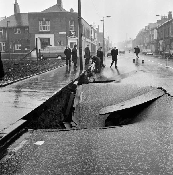 Sink hole appears on the A664 in Harpurhey, January 1969. Fortunately, it was a Sunday so the traffic was light and no one was hurt when the road sank. In the background - Beech Mount Maternity Home.