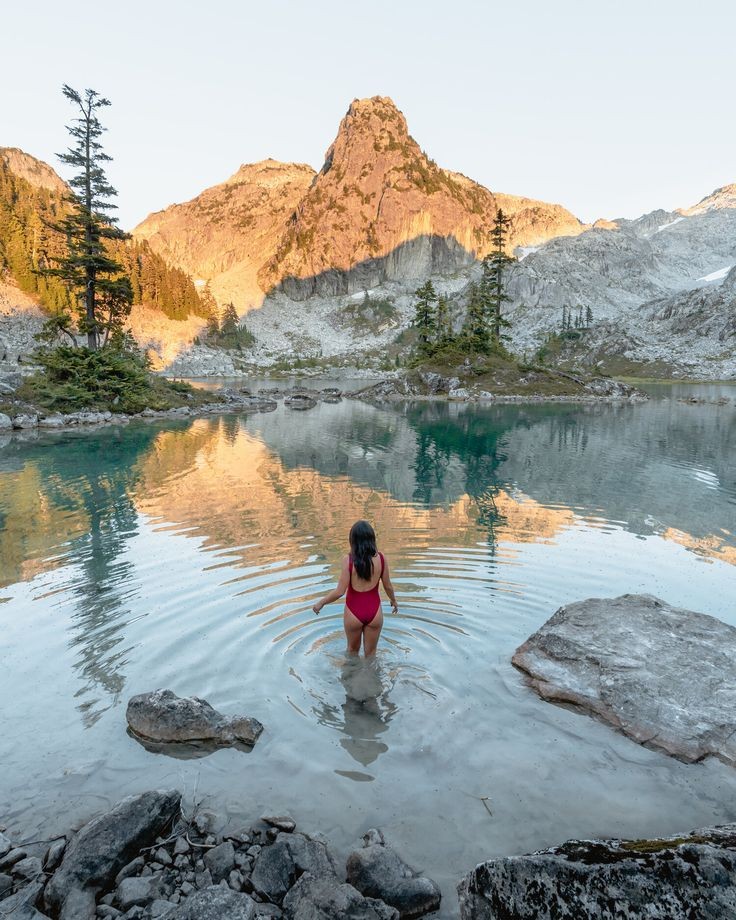 Dipping into tranquility amidst the majestic mountains of British Columbia. 🌊🏔️ 'Nature's bathtub is the best remedy for the soul.' #LakeEscape #MountainMagic #NatureQuotes