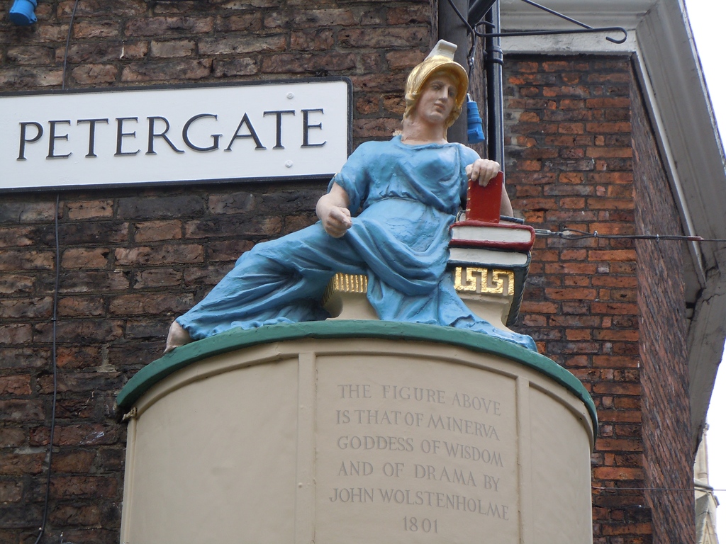 Minerva, in Minster gates opposite the top of Stonegate. The Roman goddess of the arts, culture and learning symbolizes the literary aura of this part of York. From York Through the Lens of the Press amzn.eu/d/eamBkc4 #york #yorkshire #yorkpress #yorkhistory #yorkevents