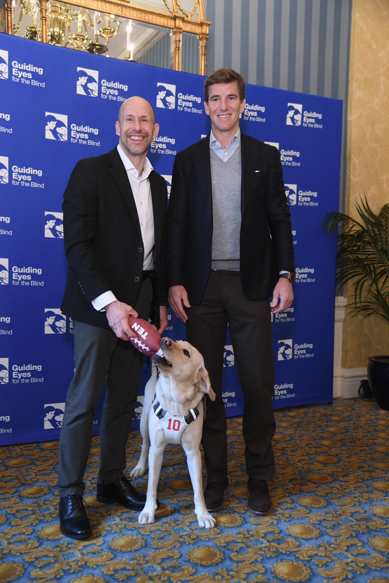 EliManning's tweet photo. I was honored to present President &amp; CEO of @GuidingEyes Thomas Panek with his newest teammate and guide dog, Ten, at the first-ever guide dog draft yesterday. I'm excited to follow Ten's journey as he joins Thomas' team! https://t.co/mxlM4DyEeB
