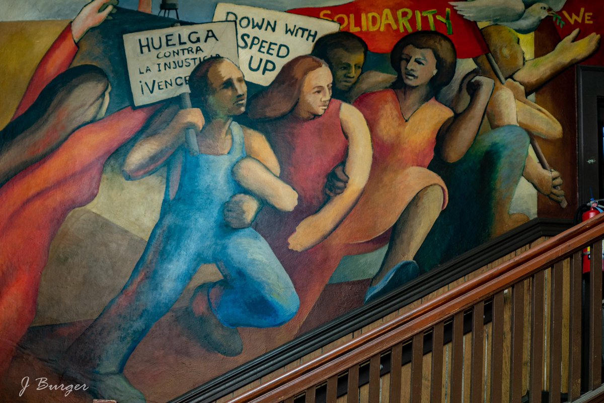 Part of the mural of workers holding picket signs