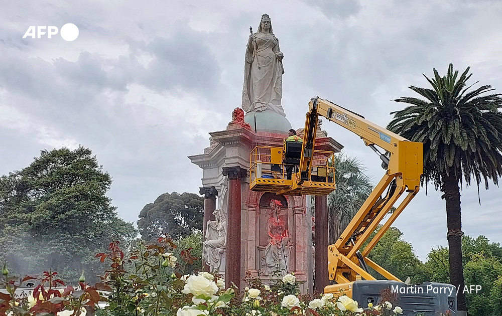 A council worker cleans a statue of Britain's Queen Victoria that was defaced in the Royal Botanic Gardens Victoria in Melbourne on January 25, 2024, ahead of Australia Day.