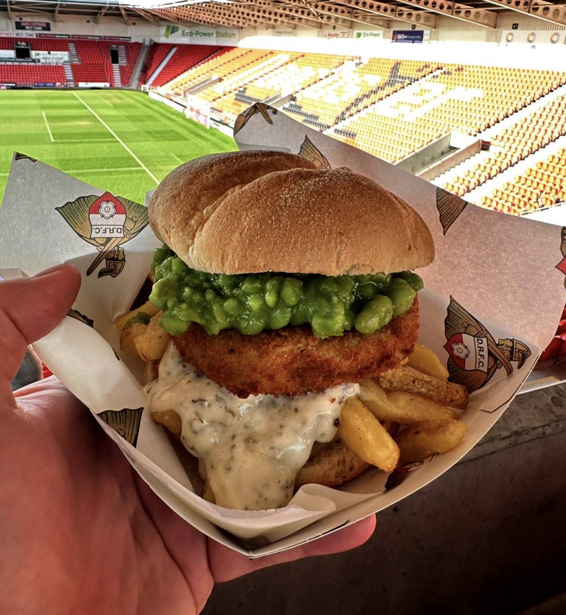 The chippy tea butty - fishcake on a bed of chips, topped with mushy peas and tartar sauce at Doncaster Rovers FC (<a href="/drfc_official/">Doncaster Rovers FC</a>) 

💷 £8