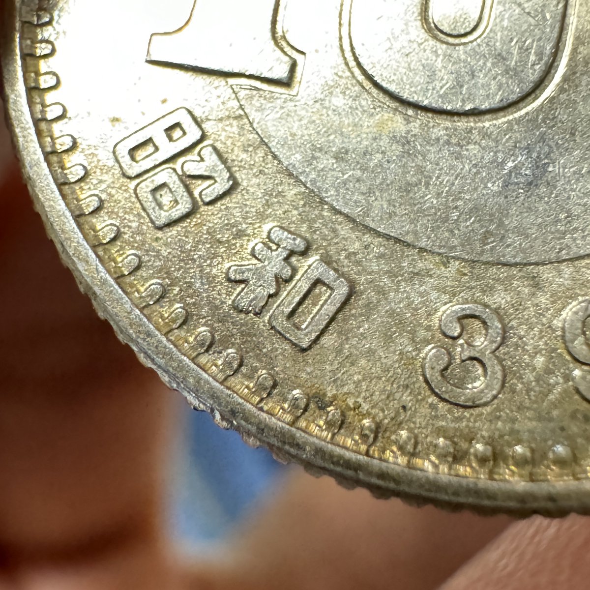 【新発見】
この位置の鋳詰まりは東京オリンピック100円銀貨としては未発見です。
(31万枚見た内の1枚目)

そもそも五輪百円自体、記念硬貨であるため刻印が安定しており、あまり手変りがありません。