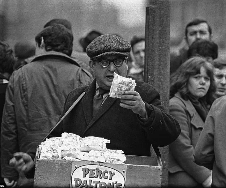 The East end dog tracks were a hugely popular destination for London residents during the 1960s. 
A peanut seller is pictured here trying to cash in on the large crowds, who flocked to bet on greyhounds. Mechanical hare tracks were first introduced in the UK in 1926.