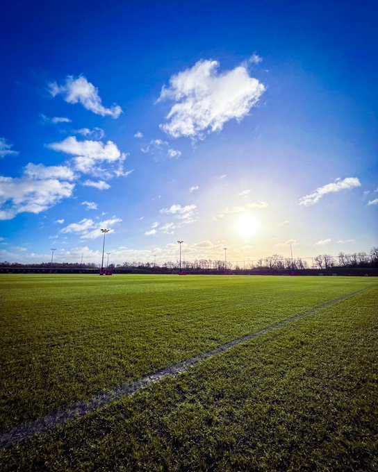 An image of the training pitches at Carrington with blue skies and a low winter sun in the background.