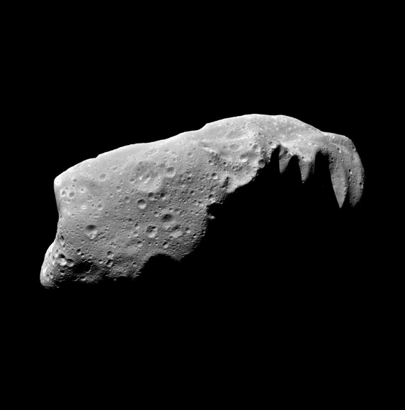 Asteroid that looks like a potato shaped gray rock, half of it in shadow.