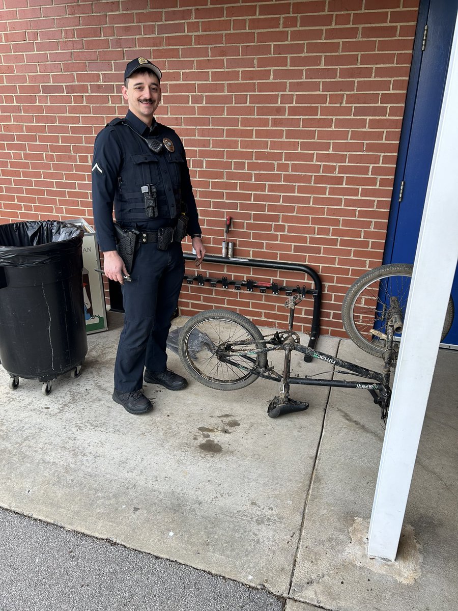 Our SRO is amazing!  While welcoming students this morning he noticed a boy struggling with a broken bike.  An hour later he has parts and is working on repairing it. #littleschoolbigheart