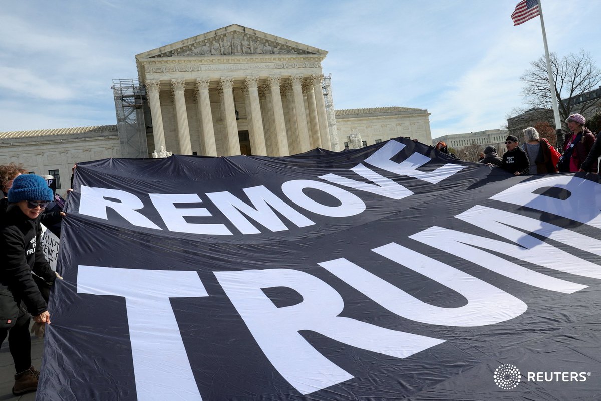 Activists hold up a banner following arguments in former U.S. President Donald Trump's appeal of a lower court's ruling disqualifying him from the Colorado presidential primary ballot, in Washington. Photo by @Moxie_Manda