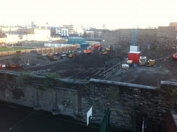 RobLooseCannon's tweet photo. Dubliners love a good secret tunnel, and there's dozens beneath our ancient city. Builders excavating on Thomas Street unearthed a forgotten network of tunnels from the days of the old Roe’s whiskey distillery, which closed in 1926.

Archaeologists initially found a layer of stratified soot, then more evidence of large furnaces. Then they discovered a subterranean complex of tunnels, three meters high and one and half meter wide. Some of these ingenious shafts were used to move heated air from the furnaces, at an uphill angle, toward the old distillery grain stores. 

The original humble whiskey producer grew exponentially during the 19th century. At its peak of operation, the warehouses alone held 23,000 casks, which is over a million gallons of whiskey.  Archaeologists believe the complete tunnel network could extend across seventeen acres, all the way down to the Liffey!

Roe’s original entrance was almost directly opposite Guinness’s.They competed for the hearts, as well as the mouths of Dubliners. When the stout superstar helped pay for the restoration of St. Patrick’s cathedral, Roe’s donated £250,000 for the improvement of Christ Church cathedral. 

The archaeologists' survey also found evidence of cooperage; the dying craft of hand-making barrels. As the largest distillery complex in the world at that time, Roe’s also hosted stables and sixteen massive fermenting vats. 

The Dublin Time Machine has previously visited the magnificent 150-foot tall smock windmill on the site, called St Patrick’s Tower. Incredibly, the massive structure survived Roes's downfall, albeit without its sails. Several historic and economic events signed the death warrant of Roes whiskey. 

The War of Independence was hugely disruptive to staffing, production, and distribution. Likewise, exports to the states were hammered by Prohibition in America. The final coffin nail was a market flooded with cheap blended scotch. Guinness now has some of its offices and car park over the site of Roe’s Whiskey Distillery. 

Of course, the Guinness brewery has extensive tunnels of its own. One which is sometimes open to visitors runs beneath James Street, connecting the brewery sites on either side of the road.

The 19th-century brick-lined tunnel has an extremely modern feeling elliptical-vaulted ceiling. In addition to personal, it also transported porter lines from their vat houses down to the racking shed. Rumour has it another tunnel, which once carried a light rail system, was not actually blocked up and is still used either to house an emergency power plant or to cater for high-class executive guests...