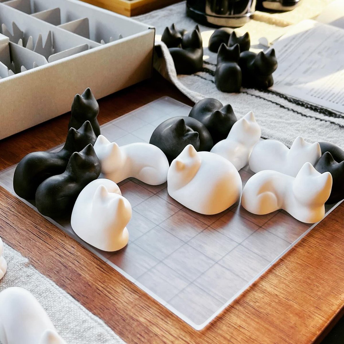 YasumiMatsuno's tweet image. ボードゲーム「Nego」。
囲碁に近いルールの陣取りゲームで、駒はご覧のとおりの猫たち。それぞれ1〜4マスを占有する猫を一定のルールに従って配置していく。最終的にマス目を多く獲得した方が勝ち。視線を受け止めてはいけないとか、ボス猫を見てはならないとか、ルールがいちいち面白い😂 

#nego