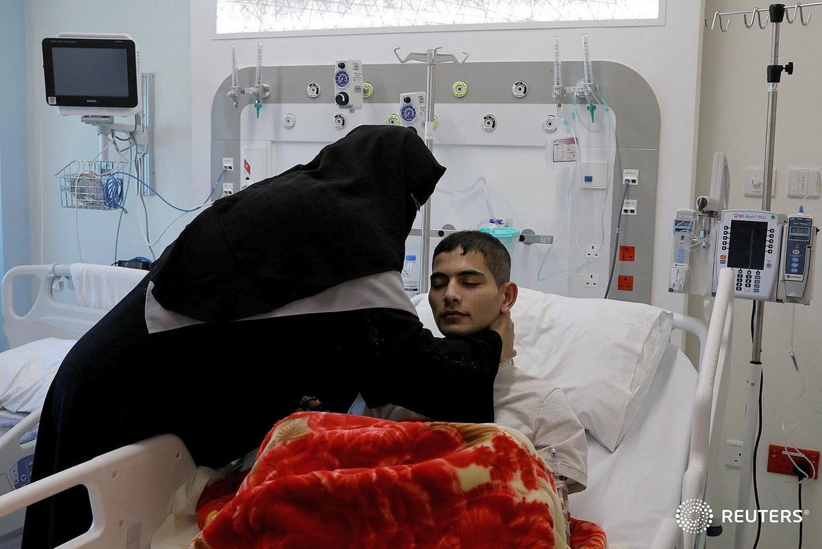 Palestinian Mohammad Al Jaafari, 18, who lost his arm to an Israeli airstrike and have multiple abdominal injuries, is being helped by his mother at a hospital, after both were evacuated from the strip by United Arab Emirates to receive proper medical care, in Abu Dhabi.
