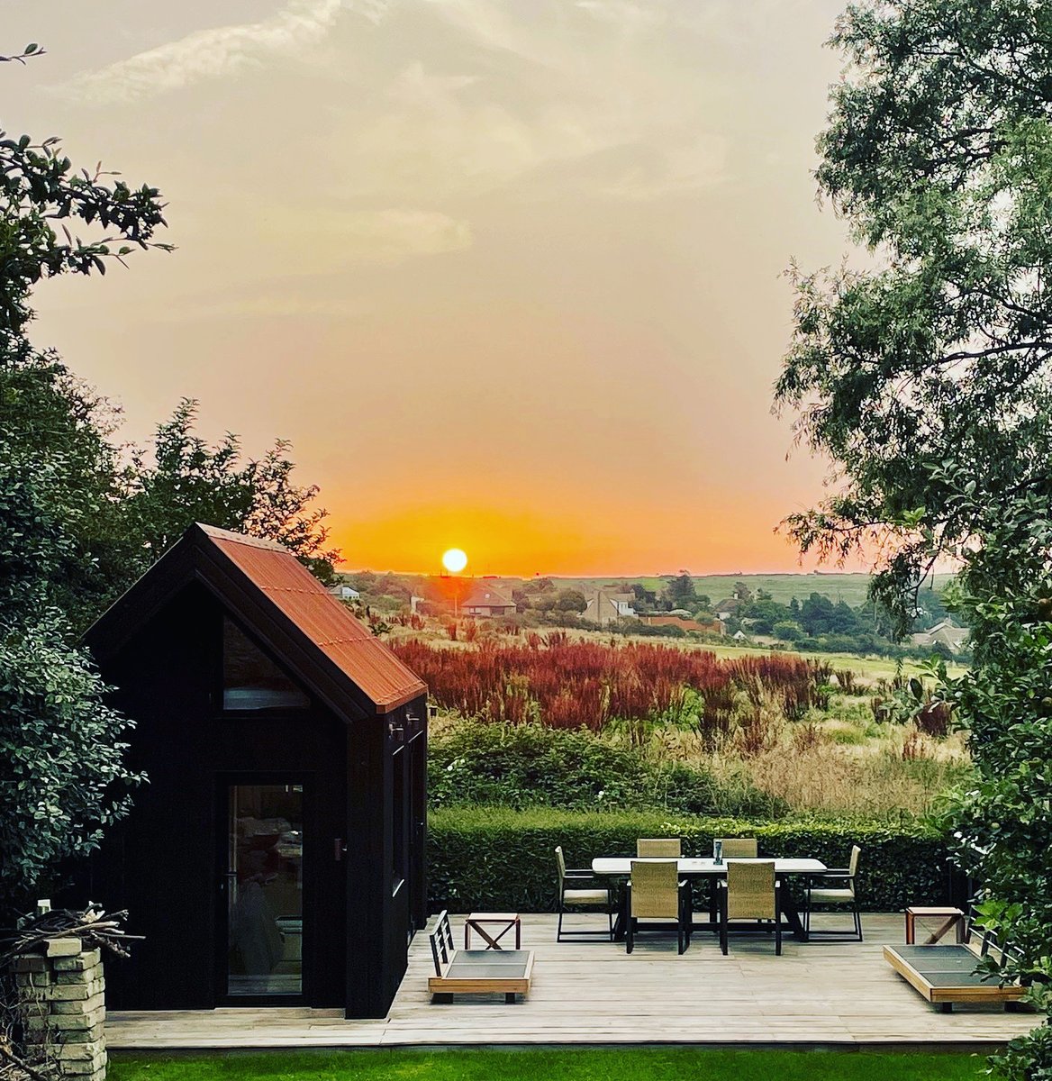 What a beautiful sunset to compliment the warm glow of this stunning cabin with our COR-TEN Roof 🌅 #CORTENRoof #cortensteel #corten #madeinbritain #madeinscotland #youdesignitwemakeit