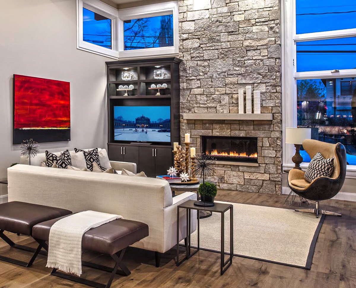 Step inside this inviting living room to take a cold weather break. Feel the warmth and ambiance emanating from the stone-framed fireplace. sdsmithhomes.com #fireplace #winterretreat #homecomforts #interiordesign #cozyhome #livingroom #customhomebuilder #sdsmithhomes