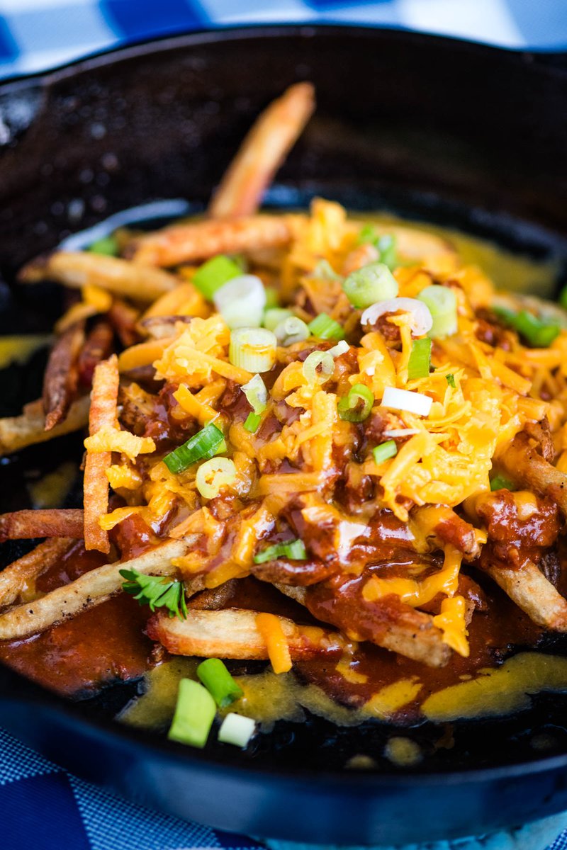 How to make loaded chili cheese fries in a cast iron skillet with crispy homemade French fries and canned chili. Easy, budget-friendly recipe that makes the best Game Day or party appetizer, and you can make it in 30 minutes or less! adventuresofmel.com/chili-cheese-f… #footballpartyfood