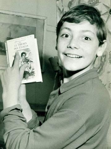 Le sourire du jeune Patrick Dewaere, 11 ans, avec Le Chemin des Étoiles, un roman de Dominique François paru dans la collection Rouge et Or (1957).
