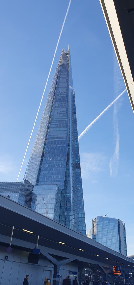 The Shard on a sunny day, with added vapour trails.