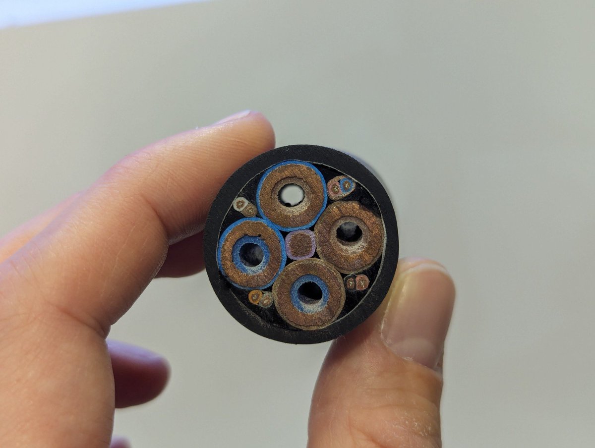 cross section of a high power electric car charging cable. the electric current is so high that the copper wires would overheat, but coolant flows through small tubes in the center of each wire.