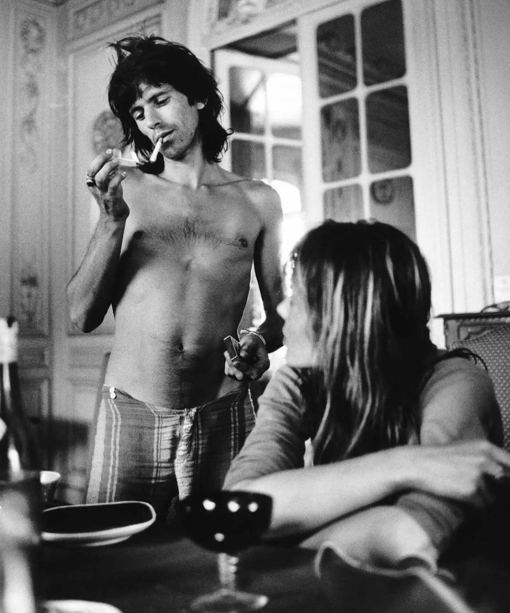 Keith Richards lighting a cigarette beside Anita Pallenberg at Villa Nellcote, photographed by Dominique Tarle in 1971.