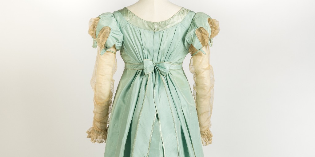 Friday Treat Time and a beautiful duck egg blue silk evening dress from the late 1810s. This exquisite example with its fuller skirt shape and elaborate trimmings reflects a move away from the neo-classical influences of the previous decade to the romantic tastes of the 1820s.