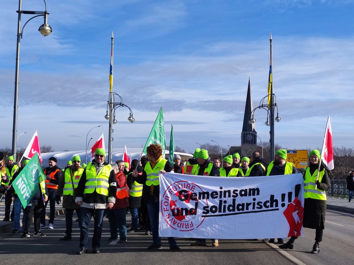 FFF_Frankfurt's tweet photo. Die Brücke ist voll. Demonstrationszüge aus Hessen und Mainz haben sich auf Theodor Heuss Brücke getroffen. Auf beiden Seiten sieht man nur Fahnen und streikende Kolleg*innen. Richtig starker Streikauftakt!! https://t.co/rBczib99Nr