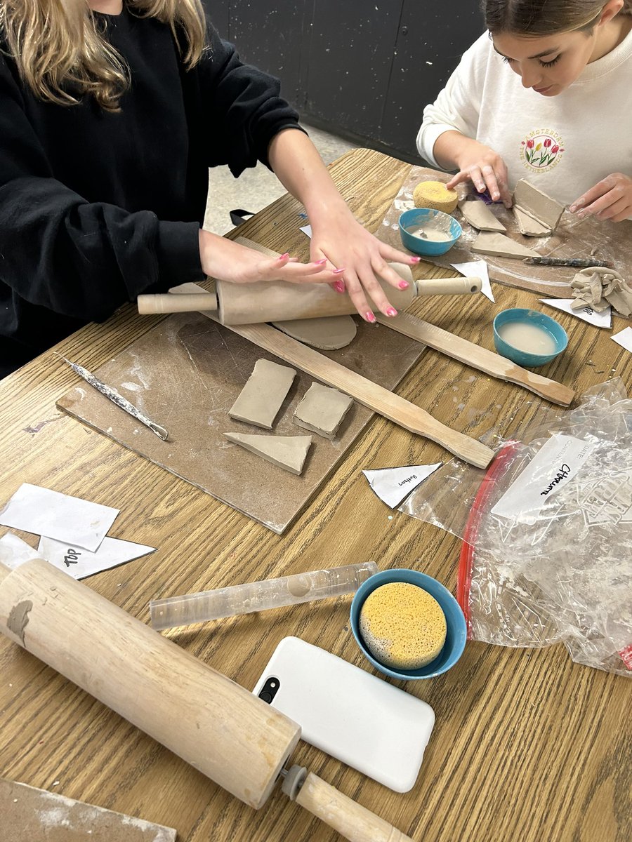 Students creating unique cake pieces learning ceramic skill #2: slab pots.