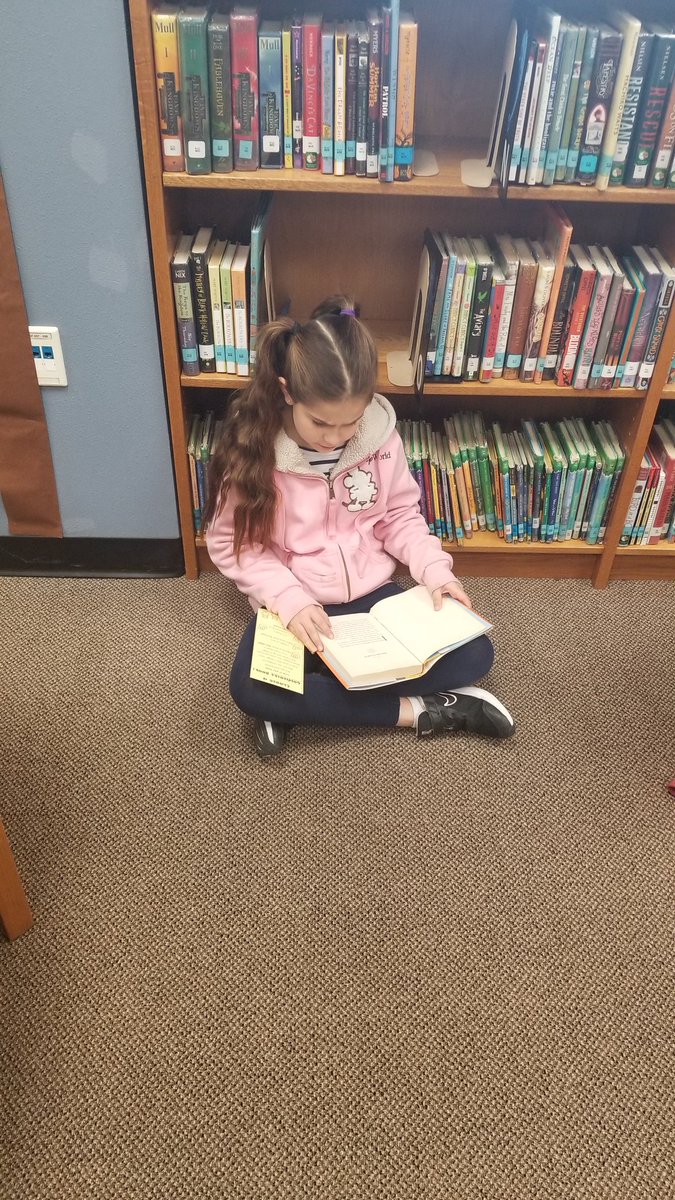bookyourtime's tweet image. Students using the "5 Finger" rule to find good fit books in the fiction section of the library.