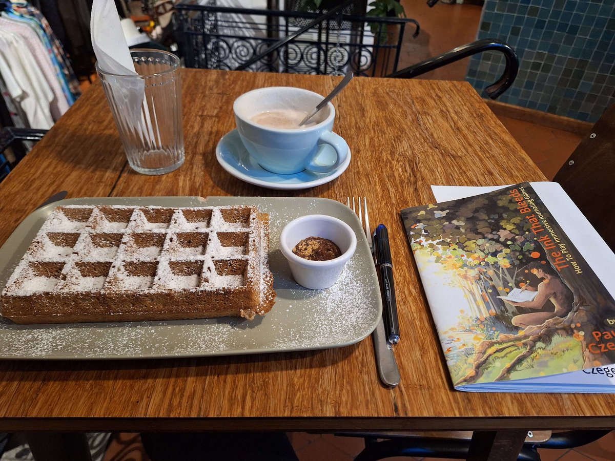 PaulCzege's tweet photo. Just got this from someone who's not on x/twitter. She's in a Belgian cafe having a Belgian๐ง๐ช waffle and reading The Ink That Bleeds.
And I'm feeling like a very cosmopolitan zinester.
#ttrpg #JournalGaming #TheInkThatBleeds #zines https://t.co/eoYo3NGTw7