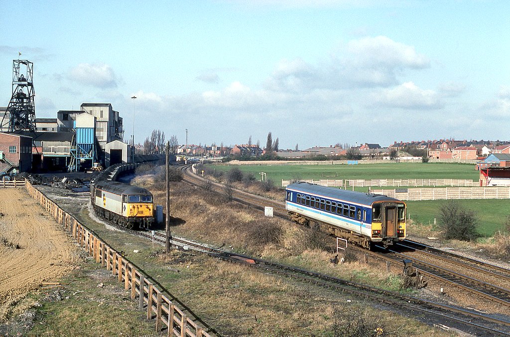 Regional Railways 153365 on a Cleethorpes to Sheffield Midland via Brigg service, passes 56007 at Kiveton Park colliery on the 19th March 1993. 

© Anthony Guppy.