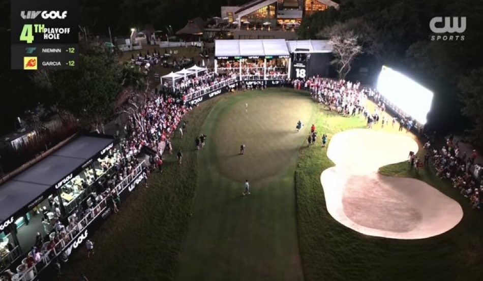 The LIV Golf scoreboard is being used to light the 18th green.