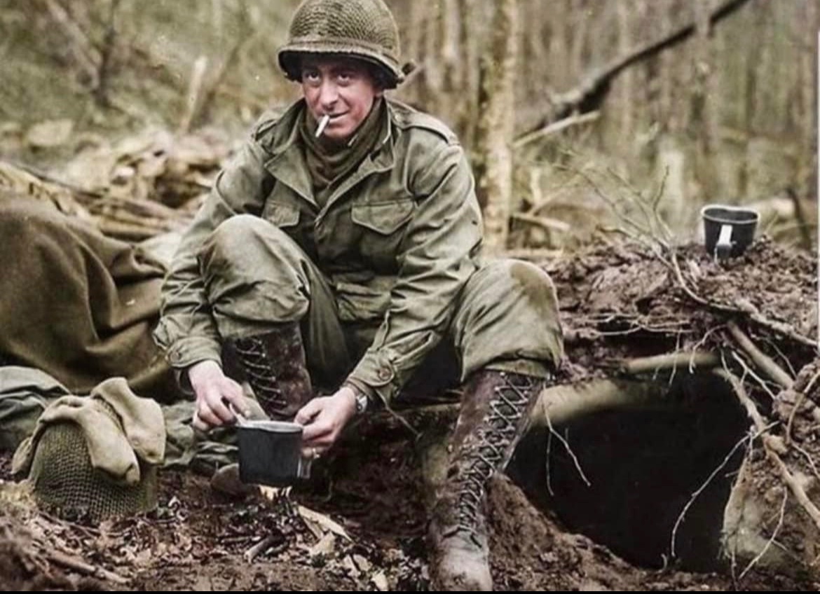 After crossing the Sauer River in February of 1945, Joseph Buccheri of the 76th Infantry Division makes a pot of hot coffee with his messtin outside his foxhole near Echternach, Luxembourg. 🪖