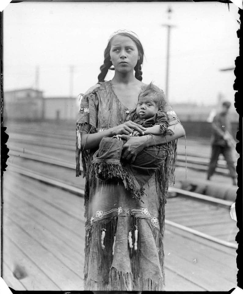 Native American woman with child at train station. ca.1930. Photo by George Leslie.