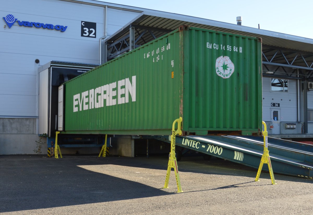 To deliver the goods, and being made to wait for unloading is a waste of time and money.

A better option is to leave the container at the loading bay to be unloaded, and go make another delivery.

Stand or deliver.

The choice is yours.